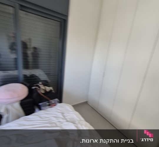חדר שינה עם ארון בגדים ומיטה
